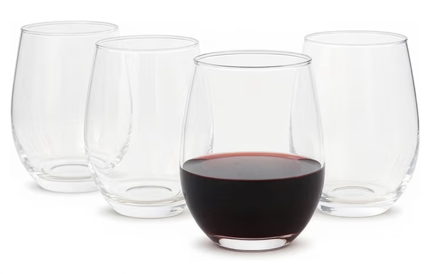 A set of stemless wine glasses, one filled with red wine