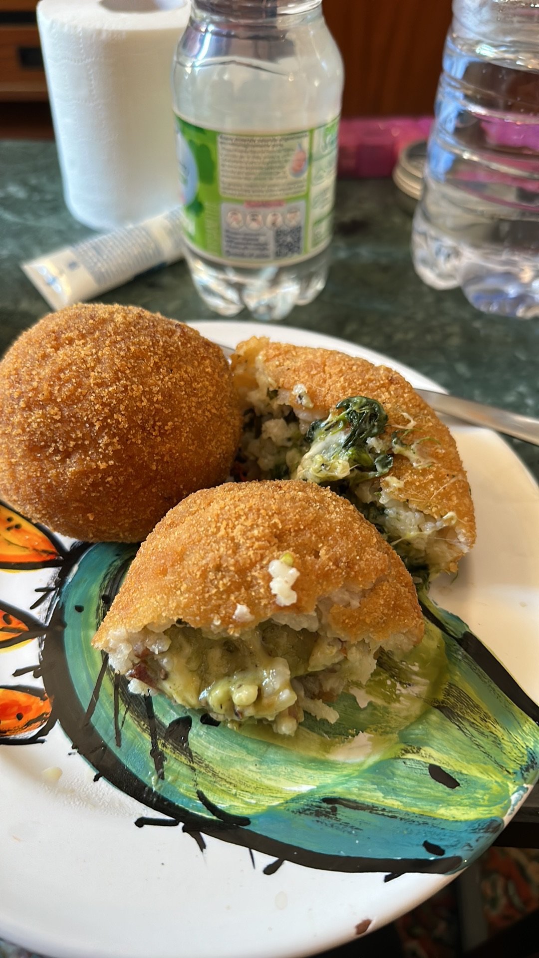 A halved arancino revealing its saffron rice, ragu, and mozzarella filling