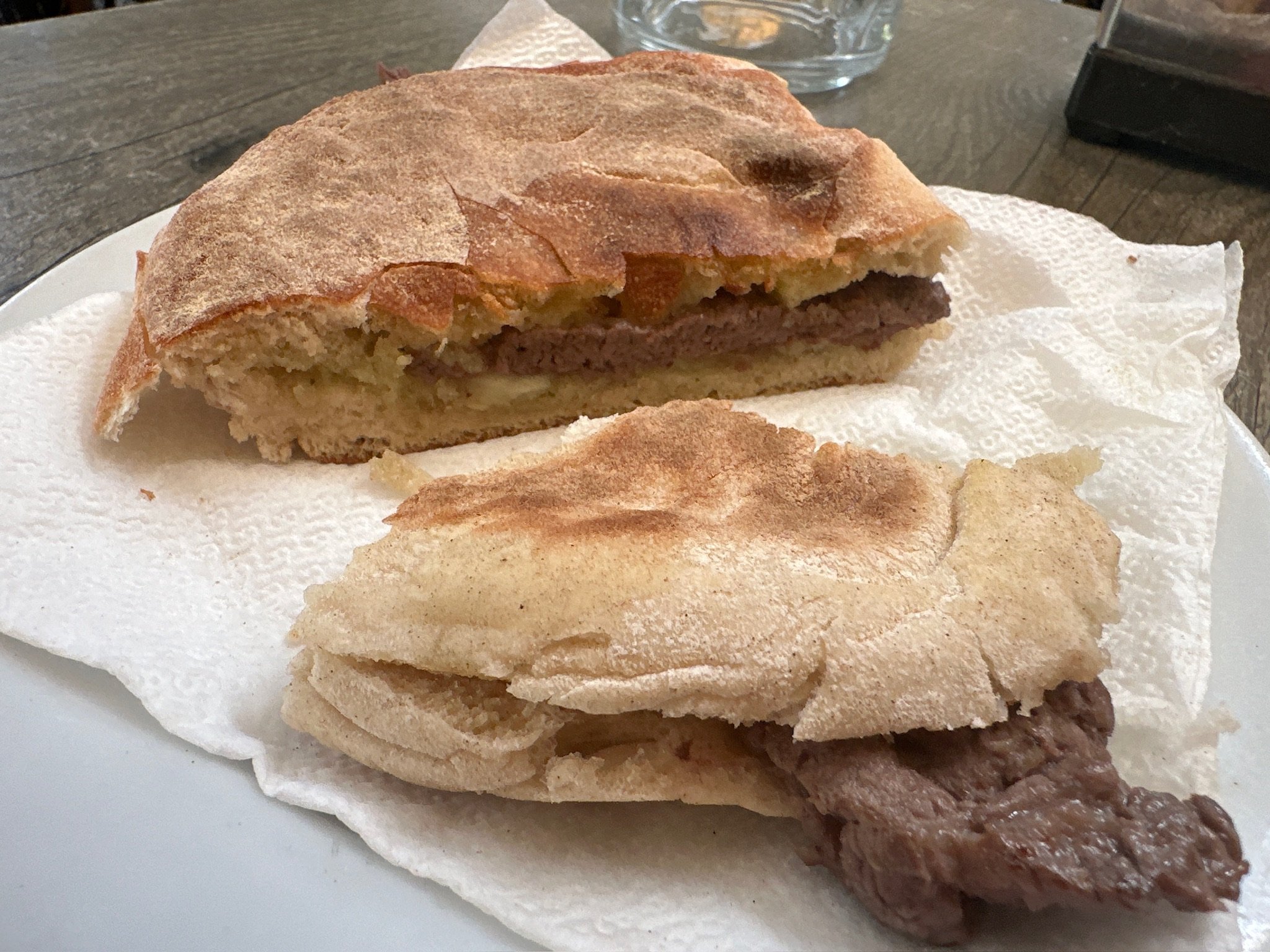 A quaint coastal shop in Funchal with a hand-painted sign advertising fresh Prego sandwiches